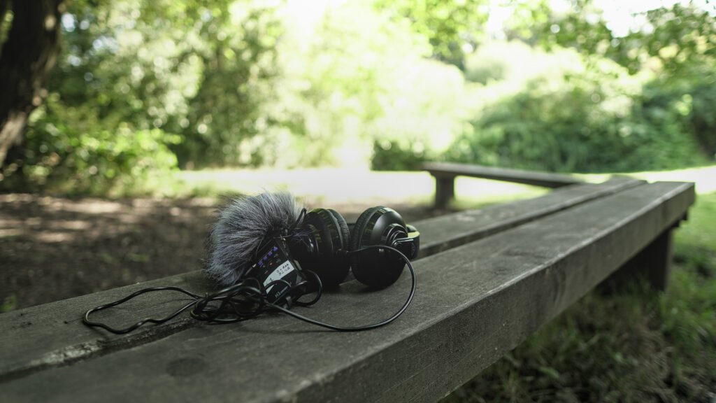 A participant listening through headphones during an outdoor creative session.