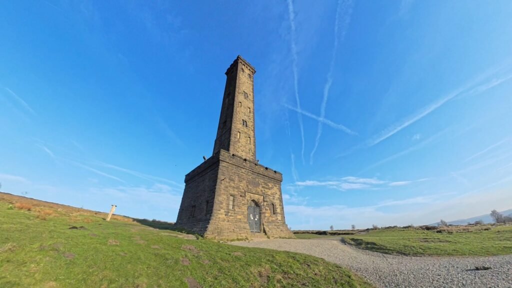 Peel Tower standing on Holcombe Hill beneath a clear blue sky.